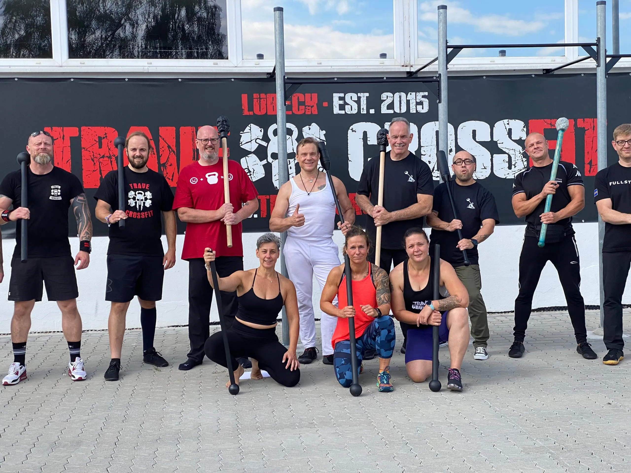 Gruppe mit Macebells vor dem Trave CrossFit Banner an der Box
