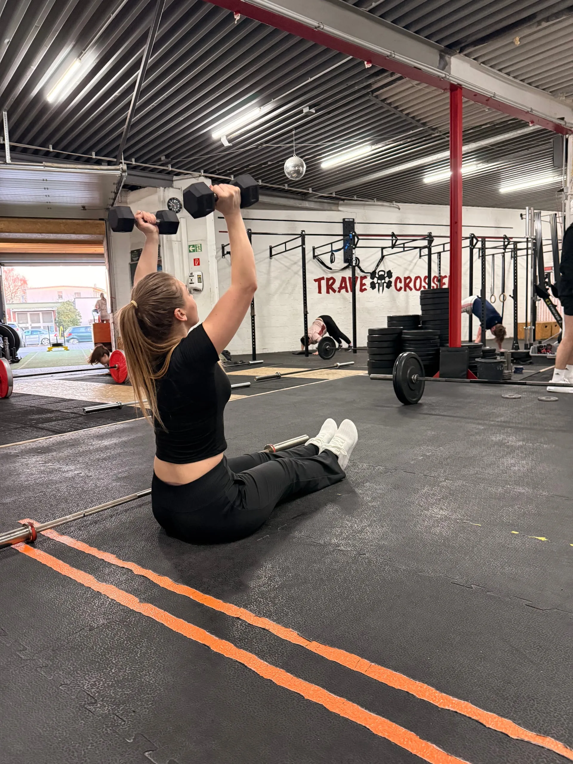 Frau bei einer Kurzhantel-Übung in der Trave CrossFit Box