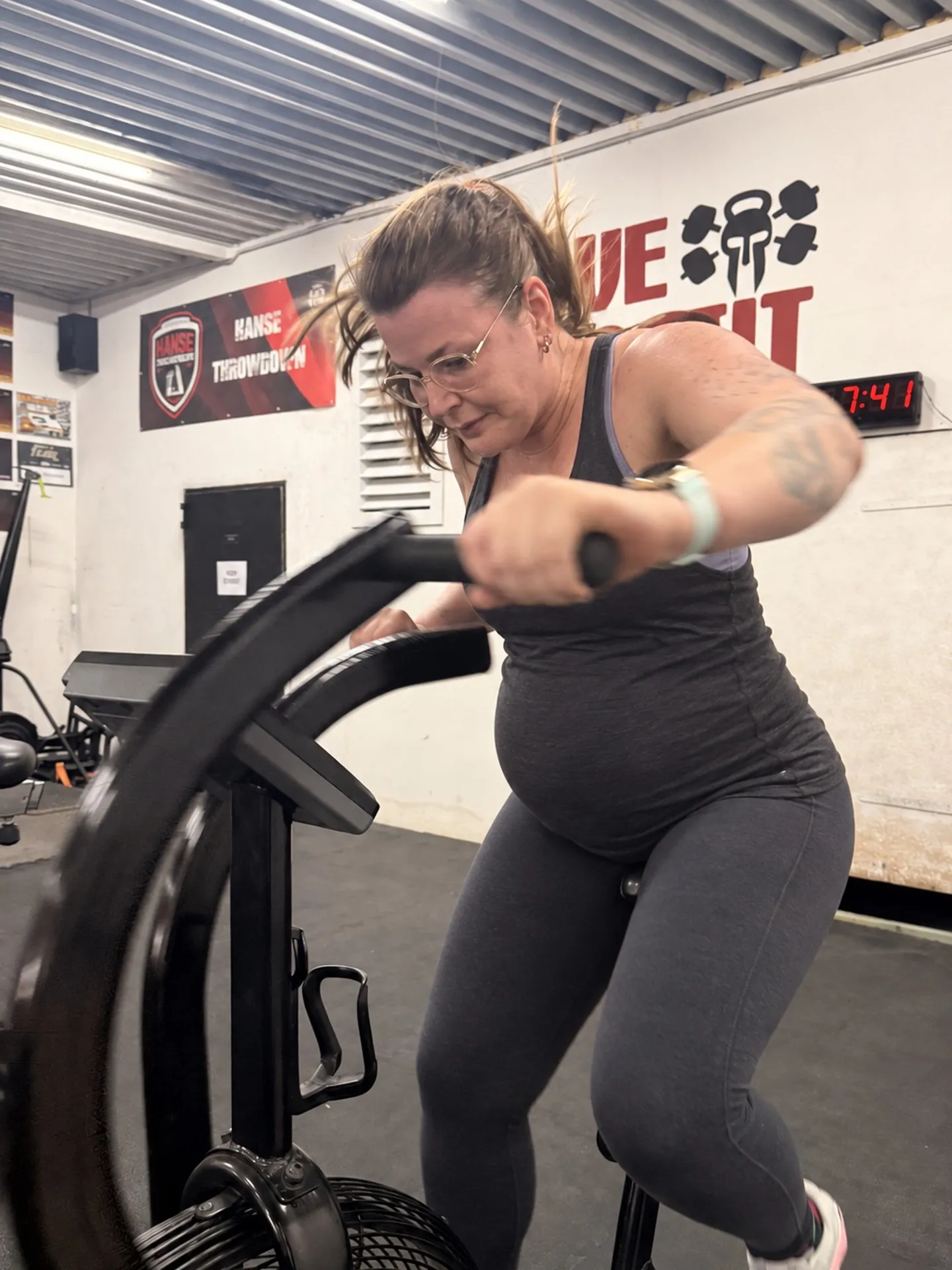 Schwangere Frau auf dem Airbike beim dosierten Training in der Trave CrossFit Box
